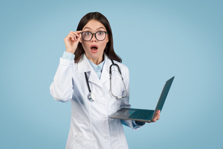 Surprised doctor with laptop, reacting to medical dataの写真素材