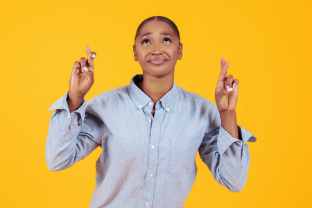 african american lady keeping fingers crossed for luck, portrait shot