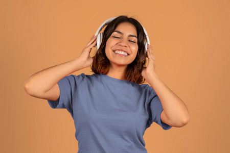 Cute young arab woman listening to music and dancingの写真素材