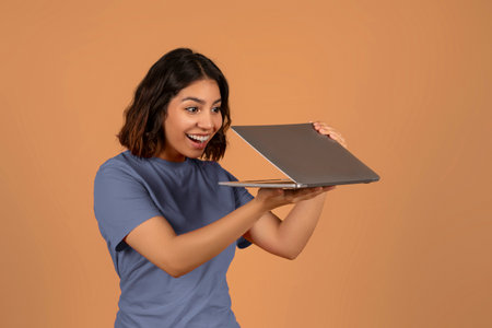 Excited young middle eastern woman looking at laptop screenの写真素材