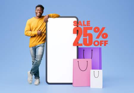 Black Guy Pointing At Empty Phone Posing With Shopper Bagsの写真素材