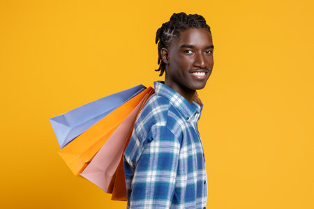 Portrait Of Happy Cheerful Black Man Holding Lots Of Bright Shopping Bagsの写真素材