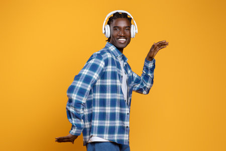 Cheerful Black Guy In Wireless Headphones Listening Music And Dancing