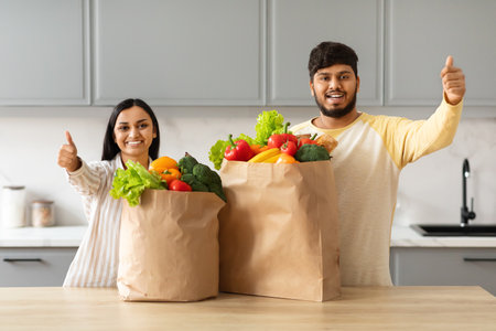 Happy young indian couple with paper bags full of groceryの写真素材