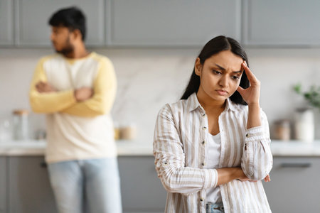 Young indian woman touching her head, have fight with husbandの写真素材