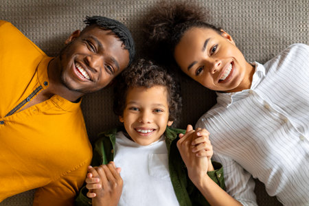 Overhead view of joyful black family lying down together