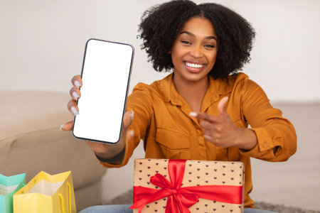 Excited African American woman showing a blank smartphone screen