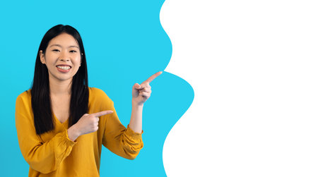 japanese woman pointing fingers aside at white copy space bubble
