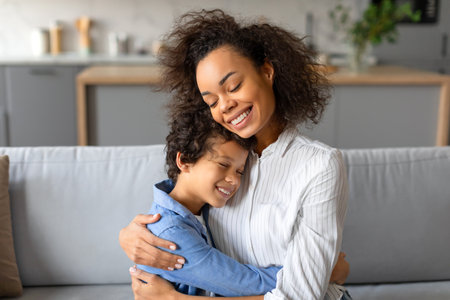Loving black mother and son share tender embrace, joy in their smilesの写真素材