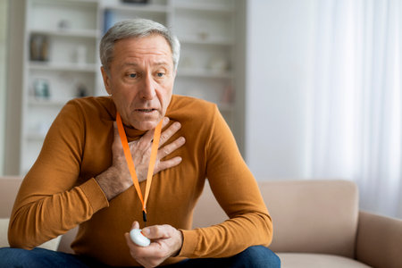 Sick senior man touching chest, pressing alarm button for emergency