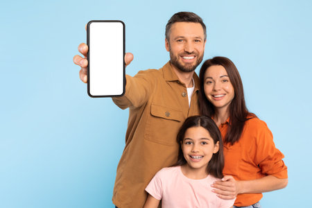 Cheerful Caucasian Family Showing Mobile Phone With Blank Screen, Studio