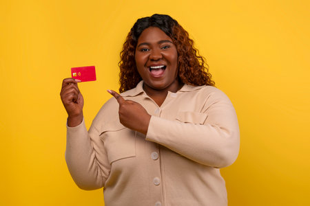 Positive chubby african american lady showing credit card