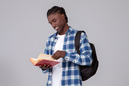 Study Concept. Smiling Young Black Student Guy With Book And Backpackの写真素材
