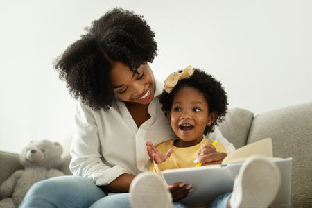 Cute african american baby girl enjoying development activities with momの写真素材