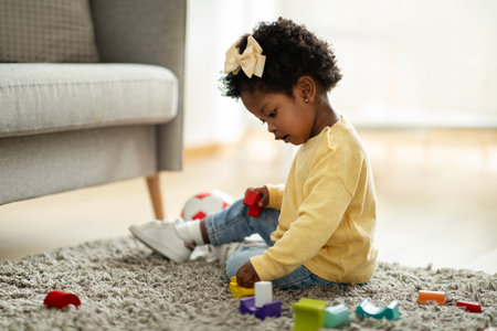 Adorable happy african american baby playing with kids toysの写真素材