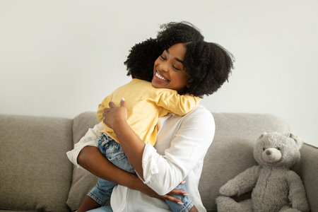 Portrait of beautiful african american woman hugging infant child