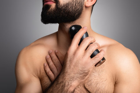 Cropped of young muscular man trimming his beardの写真素材