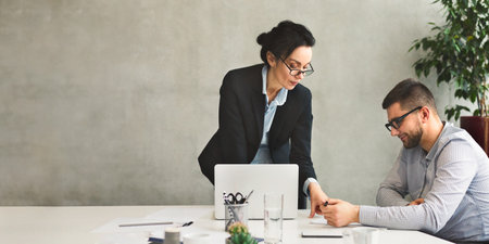 Businesswoman showing and explaining business document to partnerの写真素材