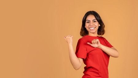 Positive arab lady showing blank space behind her backの写真素材