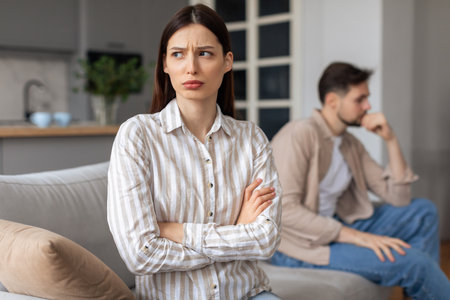 Annoyed woman with arms crossed, man in backgroundの写真素材