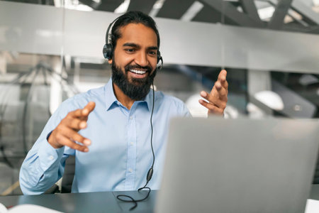 Indian Man Customer Support Manager In Headset Working With Laptop