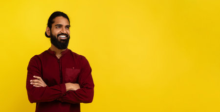 Confident indian guy looking at copy space on yellowの写真素材