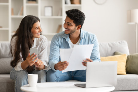 Hindu couple planning finances with documents and laptopの写真素材