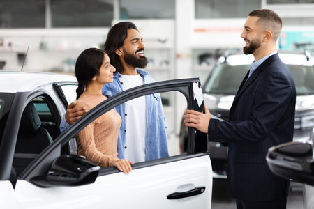 Salesman opening car door for customers