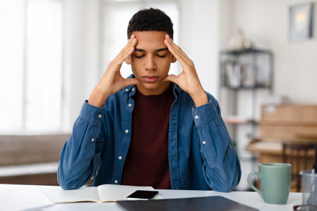 Stressed man with headache at computerの写真素材