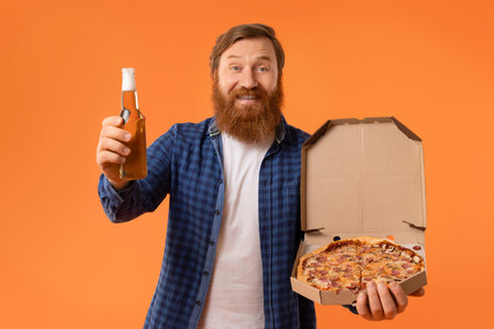 Redhaired bearded guy holding pizza box and beer bottle, studioの写真素材