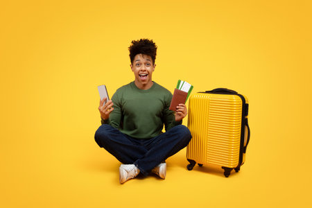 Excited traveler with phone and suitcaseの写真素材