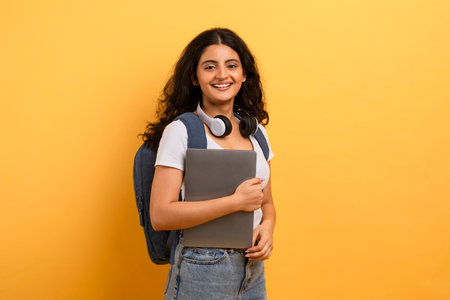 Joyful student with headphones and laptopの写真素材
