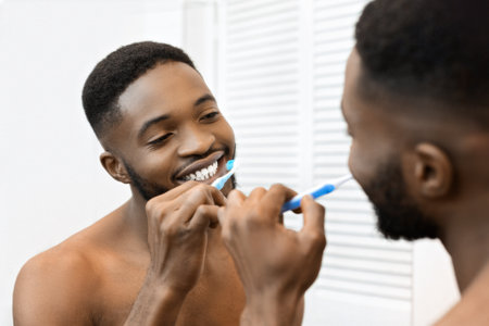 Man brushing teeth in front of bathroom mirror