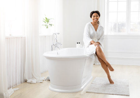 Smiling woman sitting on edge of bathtub