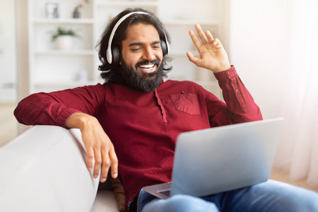Man in video call wearing headphones at homeの写真素材