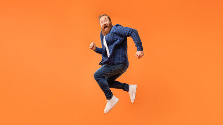Joyful man with beard jumps and shouting in excitement, studio