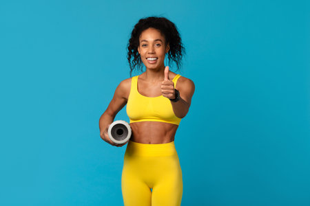Athlete gives thumbs up with yoga mat