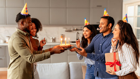 Friends presenting a birthday cake to a womanの写真素材