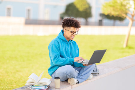 Student with laptop working outdoors, studying at parkの写真素材