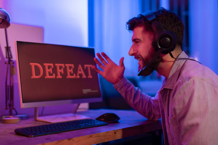 Gamer with defeat message on computer screen
