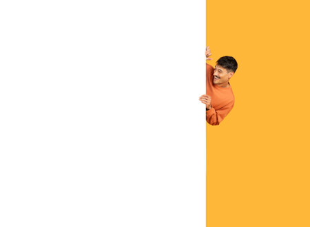 Man peeking from behind a blank bannerの写真素材