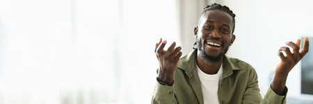 Cheerful african american man talking to camera and gesturingの写真素材