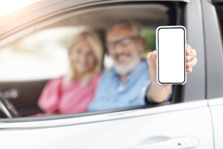 Seniors showcasing smartphone in car, traveling together