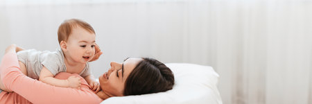 Loving young mom playing with her adorable child at homeの写真素材