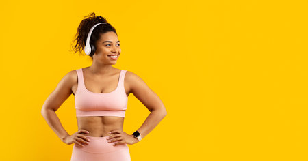 Happy african american woman with headphones on yellowの写真素材