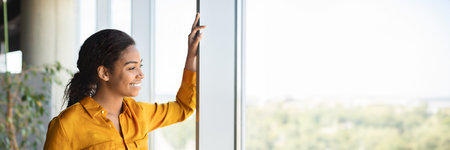 Successful african american businesswoman standing by window in coworking office
