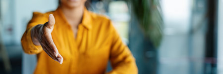 Cropped black businesswoman extending hand for handshake at officeの写真素材