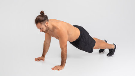 Man Performing Push Ups on White Background
