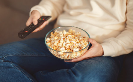 Man Holding Bowl of Popcorn and Remote Control, Croppedの写真素材
