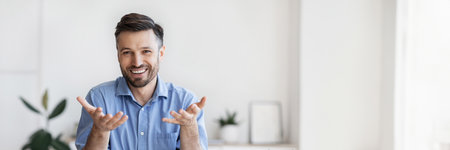 Successful handsome businessman sitting at desk in office, talkingの写真素材